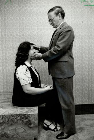 Healing hands: Rev. Alex Holmes of Caro: Mich.: lays his hands in prayer on the head of Mrs. Enid Levy of Toronto