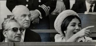 The Empress of Iran proves a real racing fan as she watches the Shahanshah Plate at Greenwood yesterday with the Shah and Lt.-Gov. Rowe. The Shah made the presentation to the winner