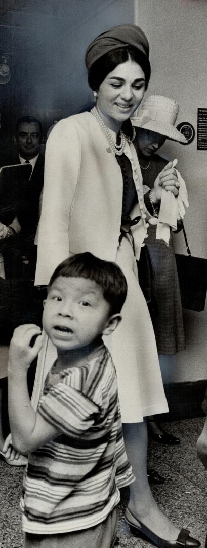 What Empress?, A youngster is startled by news photographers and appears to be unaware that Empress Farah of Iran is passing by him at the Hospital for Sick Children