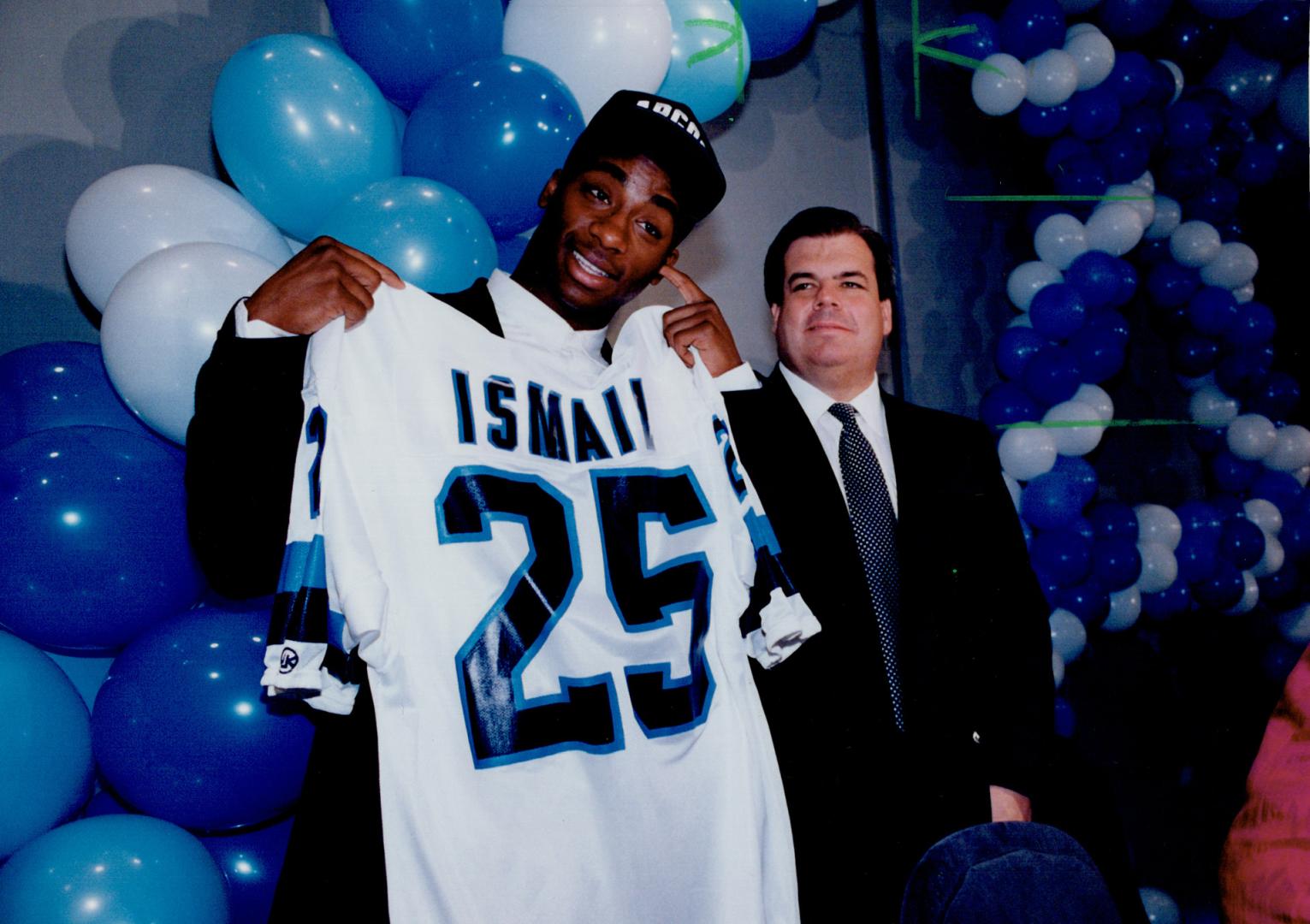 Part of the team: Raghib (Rocket) Ismail shows off his new Argo sweater at a news conference in Toronto this week as Argos owner Bruce McNall looks on