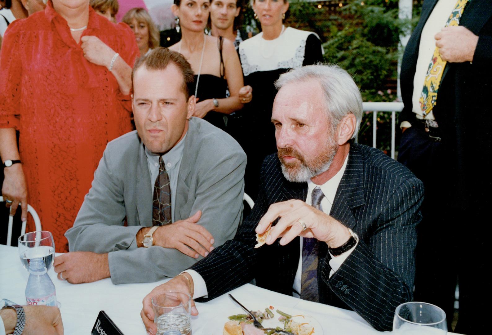 Actor Bruce Willis, left, holds court at the Bellair Cafe in Yorkville with Canadian director Norman Jewison before last night's world premiere of Jewison's in Country