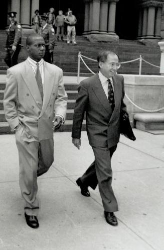 Sprinter Ben Johnson, left, leaves a Toronto court yesterday accompanied by lawyer Martin Kerbel after pleading guilty to assault