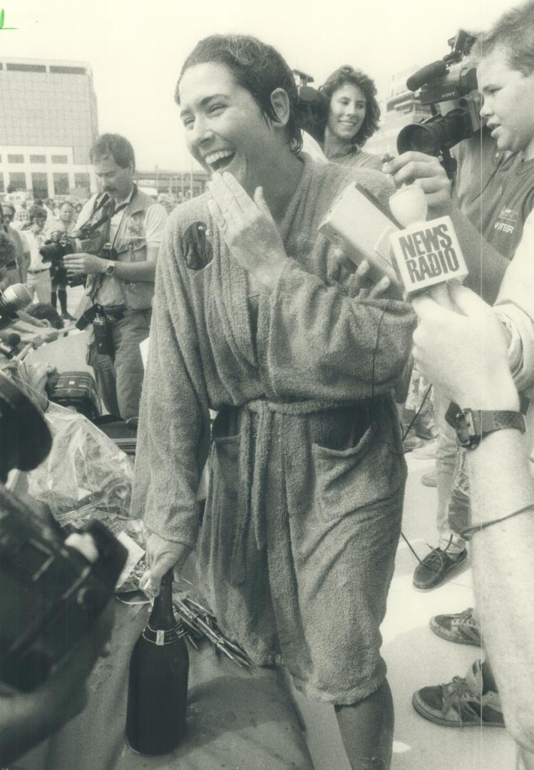 All smiles: The marathoner, who estimated she lost about 40 pounds during her record-setting swim, gets ready to replenish some of that loss with welcoming champagne