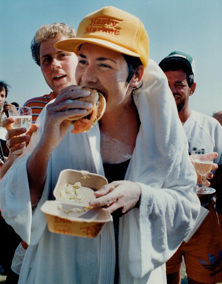 Marathoner Vicki Keith bites into her first solid food in two days after struggling ashore in Chicago from her 72-kilometre (45-mile) crossing of Lake(...)