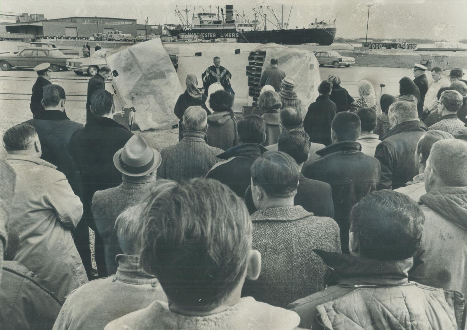 Under chill skies which lent a suitably sombre air to the occasion, work on Toronto's bustling waterfront came to a halt at noon today for a mass in h(...)