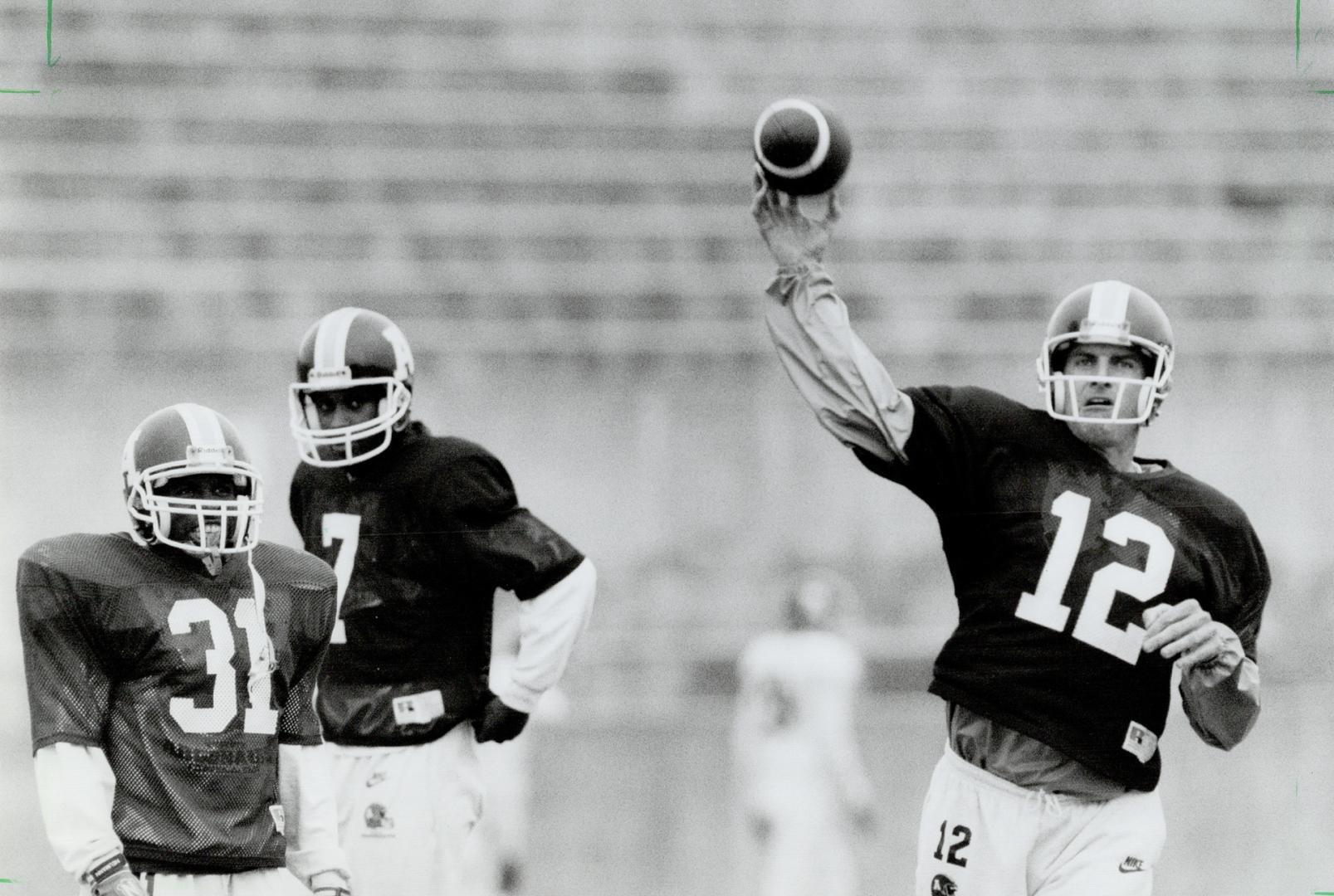 Mike Kerrigan (12) with Mike Clemons (31) and Marvin Graves