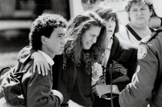 Grieving a loss: Friends of 17-year-old Marnie Kimelman, killed by a bomb on a Tel Aviv beach, hold one another as they leave Adath Israel Synagogue after her funeral service yesterday