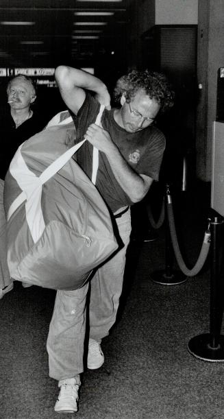 Mournful return: Louis Resnick, the uncle of slain teenager Marnie Kimelman, carries his niece's belongings through Pearson International Airport yesterday