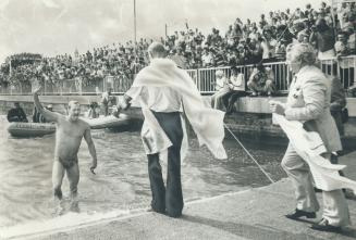 Crowds cheer John Kinsella as he walks ashore after swimming Lake Ontario in record time of 13 hours, 49 minutes