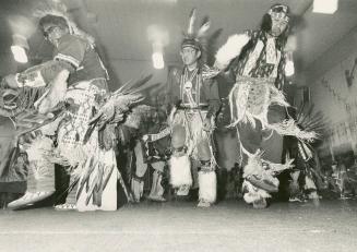 Colorfully attired Ojibway from the White Fish Bay bond do some lively stepping in a vigorous dance at the band's traditional powwow.