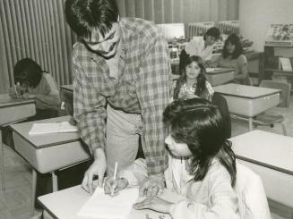 Allan Raslack, 33, principal of Grassy Narrows School, helps Rebecca Fobister, 12