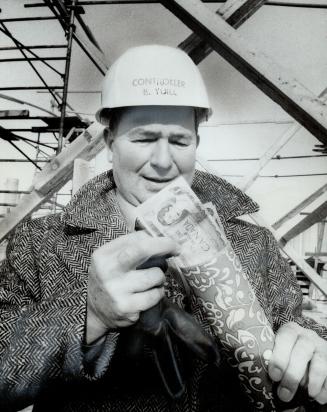 Autographed $1 bills are put into a time capsule by Controller Robert Yuill