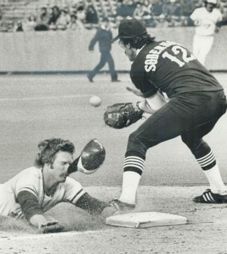 Jays's Roll Howell slides safely into third base as Eric Soderholm waits for ball