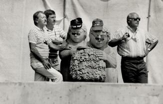 At bottom, stone-faced fans peer through sunglasses at a race program