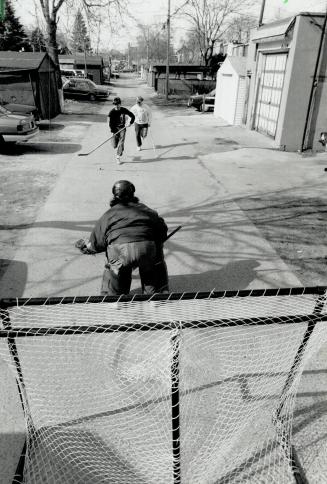 Back Lane breakaway. Above, Brendan Clarke, 17, breaks in on goal playing ball hockey yesterday in the Hanson St.-Coxwell Ave. area. Below, Clarke singals his goal on netminder Derrick Robak, 16