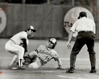 Outta there! Blue Jay shortstop Luis Gomez successfully aborts stolen base attempt by Milwaukee's Robin Yount as umpire Russ Goetz readies his leave-h(...)