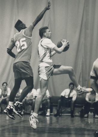 Chris Delaney of Cardinal Leger jumps to score despite being fouled by Mark Elcock of George Harvey at 11th high school Basketball Classic at Humber College yesterday