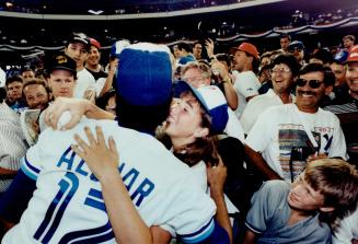 All-Star hug: A young Blue Jay fan embraces Toronto second baseman Robrto Alomar yesterday as Number 12 signed autographs before joining the All-Star Game at the sold-out SkyDome