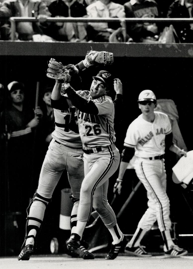 Crunch! I've got it! I've got it! Cleveland catcher Joel Skinner and third baseman Brook Jacoby chase down a Jay popfly and manage to record the out