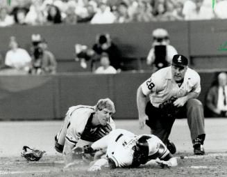 . . . and applies the tag on the Jays baserunner as umpire Larry Young looks on . .