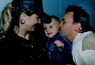 Tha's my boy: Brandon Wells is the centre of attention at Pearson airport yesterday as his pop, pitcher David Wells, plants a kiss while mom Wendy looks on