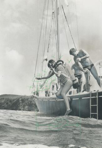 Going down into the clear blue waters of the Caribbean is a scuba diving student on her first solo