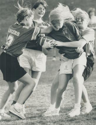 Sugar and spice and everything nice? A ball carrier for the Lawrence Park Panthers is stopped in her tracks by three Leaside Lancer defenders during s(...)