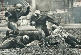 Friend or foe? Jim Christoff isn't too sure which is which as he churns through the mud at Birchmount Stadium yesterday as he helped his Midland team (...)