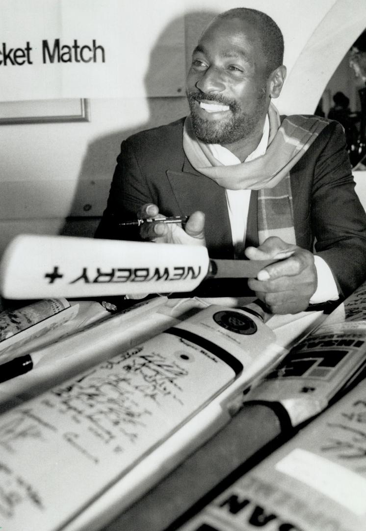 Cricket's great one: Cricket star Viv Richards autographs bats yesterday as he helps promote today's United Way cricket match