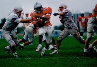 Runningback Alpheus Brown, 21, fends off his York Yeomen teammates during a workout