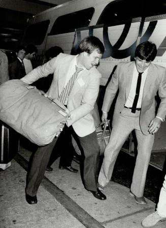 The Axemen cometh: Bob Trainor (left) and Acadia Axemen teammate fire gear into hotel-bound bus last night after arrival for Saturday's College Bowl showdown with Alberta Golden Bears