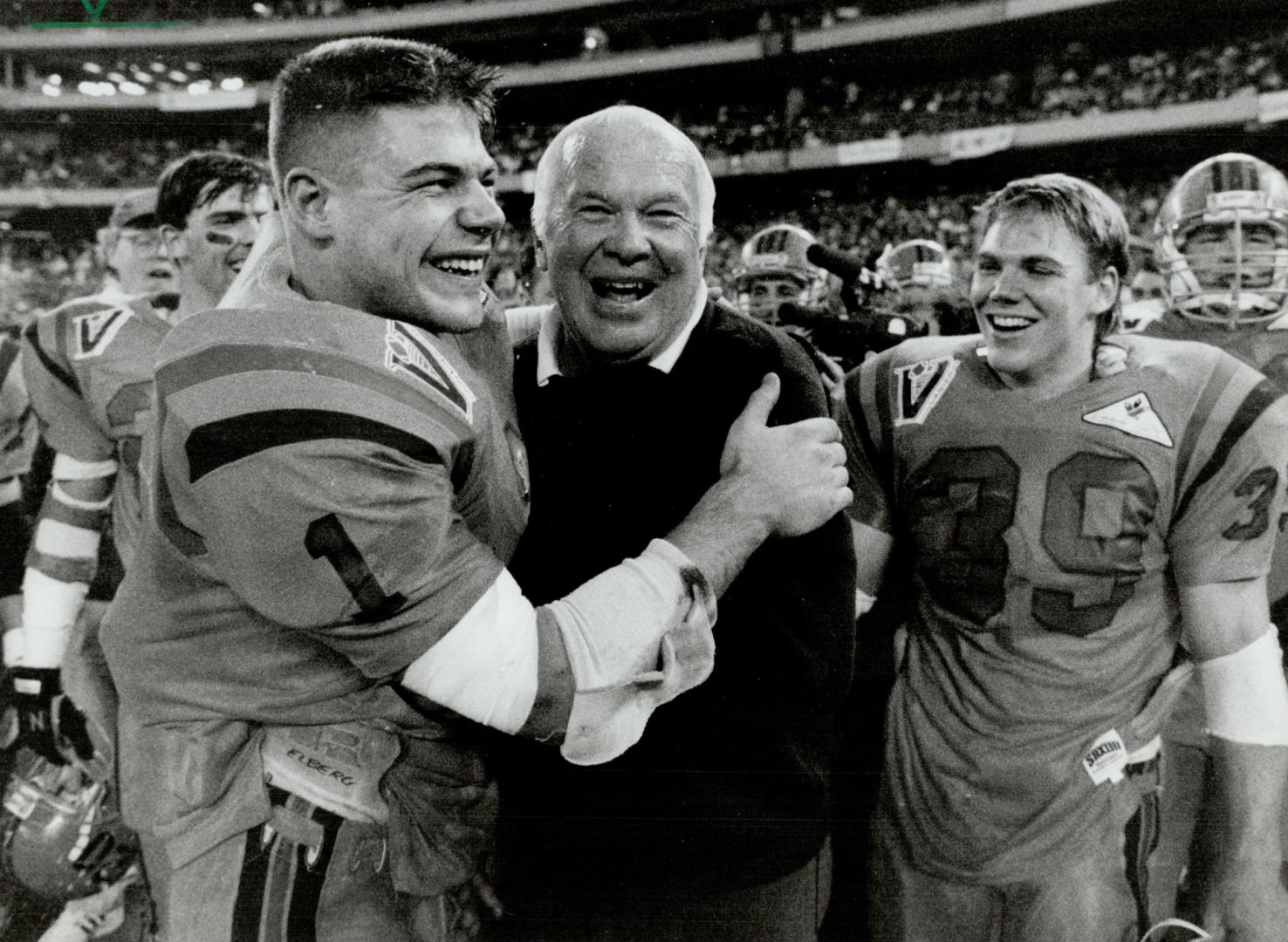 Gaels celebrate: Standout running back Brad Elberg hugs Queen's coach Doug Hargreaves after yesterday's Vanier Cup win