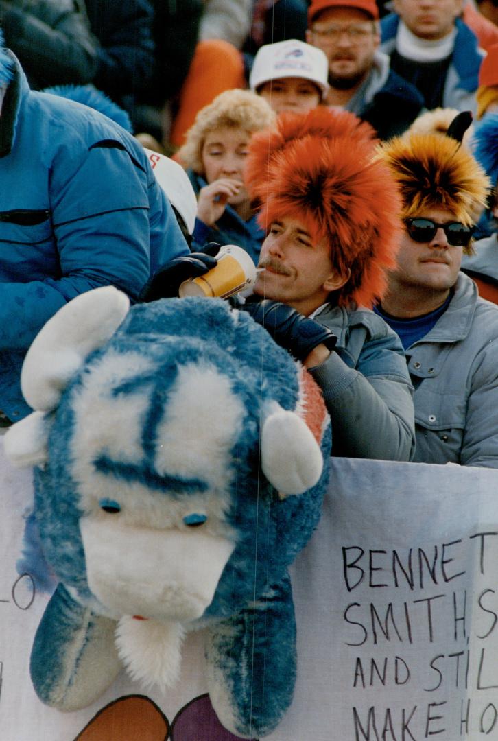 Bills boosters come in many shapes and sizes and under varying layers of clothing (at top), to cheer on quarterback Jim Kelly (above, taking a snap fr(...)