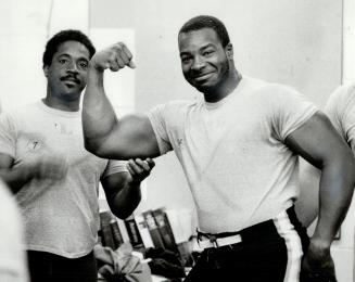 Checking for air?: Quarterback Condredge Holloway (left) helps defensive lineman James Curry strike a macho pose for the camera