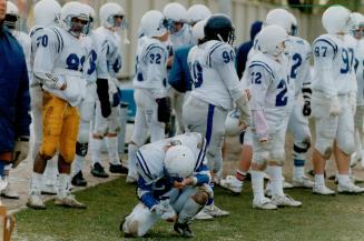 A member of Henry Carr's junior football team bows his head after losing to Michael Power