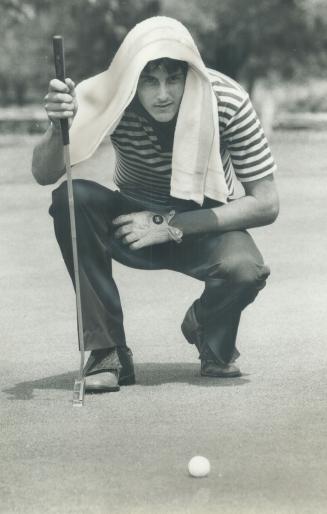 Hot time: It certainly was hot at the City Buick Pro-Junior Classic at Islington Golf Club yesterday and Wayne Chiky of Pine Hill used a towel to protect his head from sun while lining up a putt