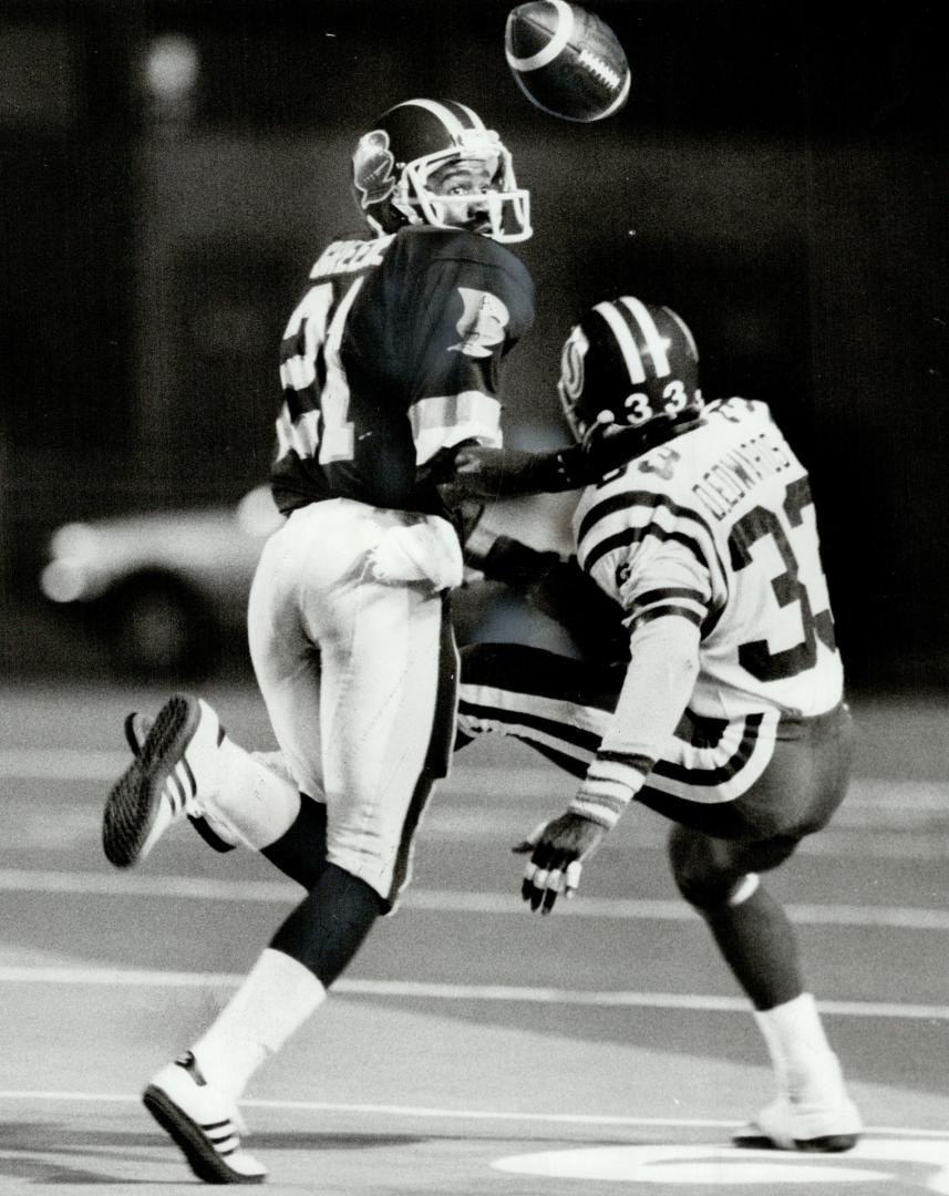 Argos' Marcellus Greene, left, fights for ball with Roughriders' Dwight Edwards, a former Argo, and Greene comes up with it for an interception with one-handed juggling act