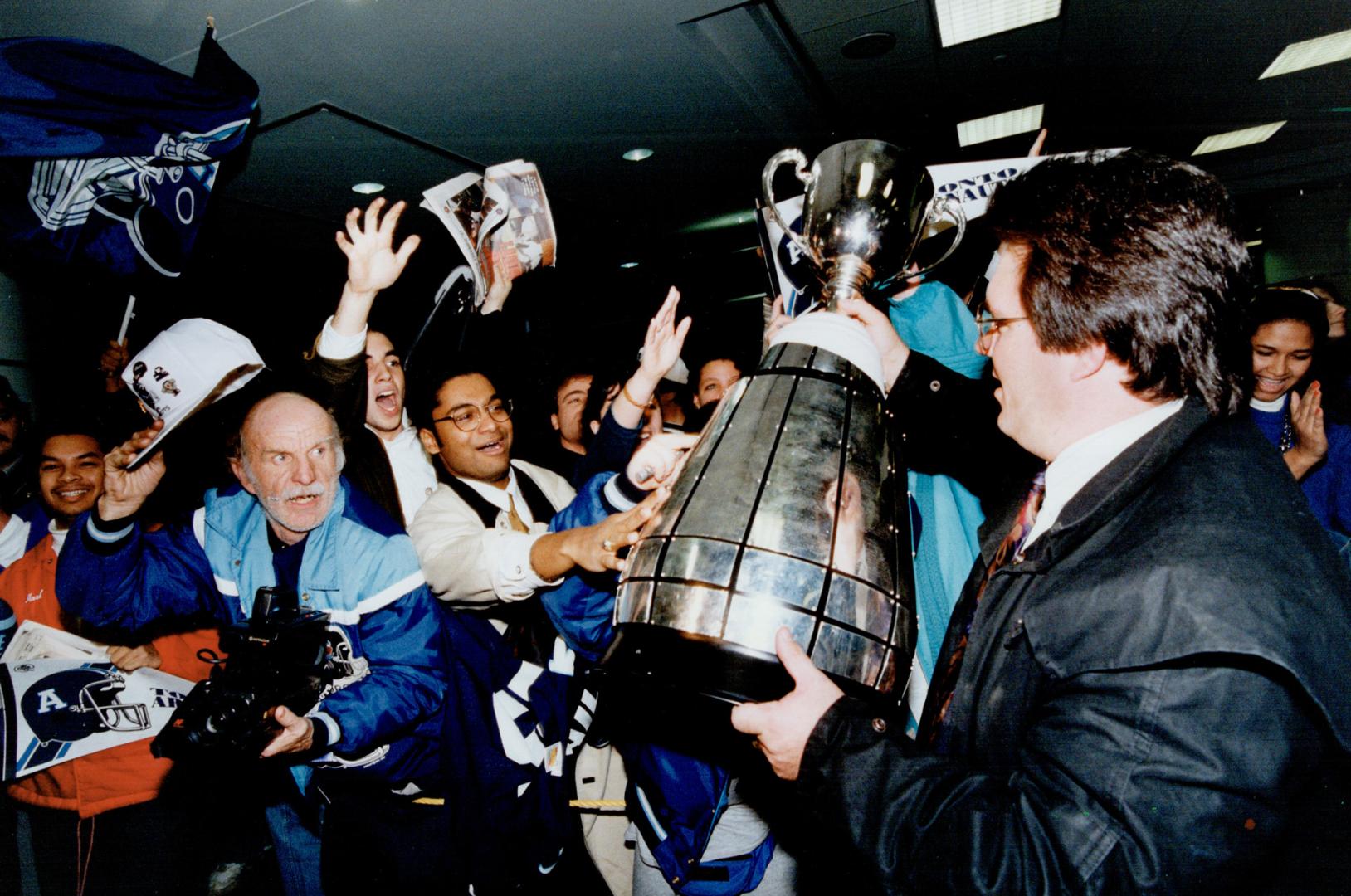 Airport celebration: Argo GM Mike McCarthy shows off the Grey Cup, which was being held together with tape yesterday after a bolt came loose