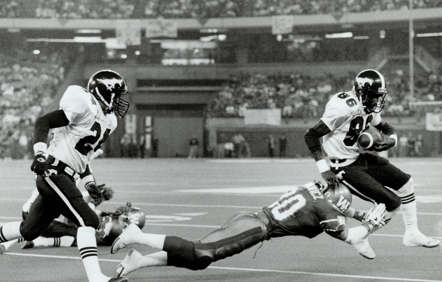 Field day for the passing game: Stamps wide receiver Pee Wee Smith turns upfield to face diving Bombers defensive back Jayson Dzikowicz after catching a pass