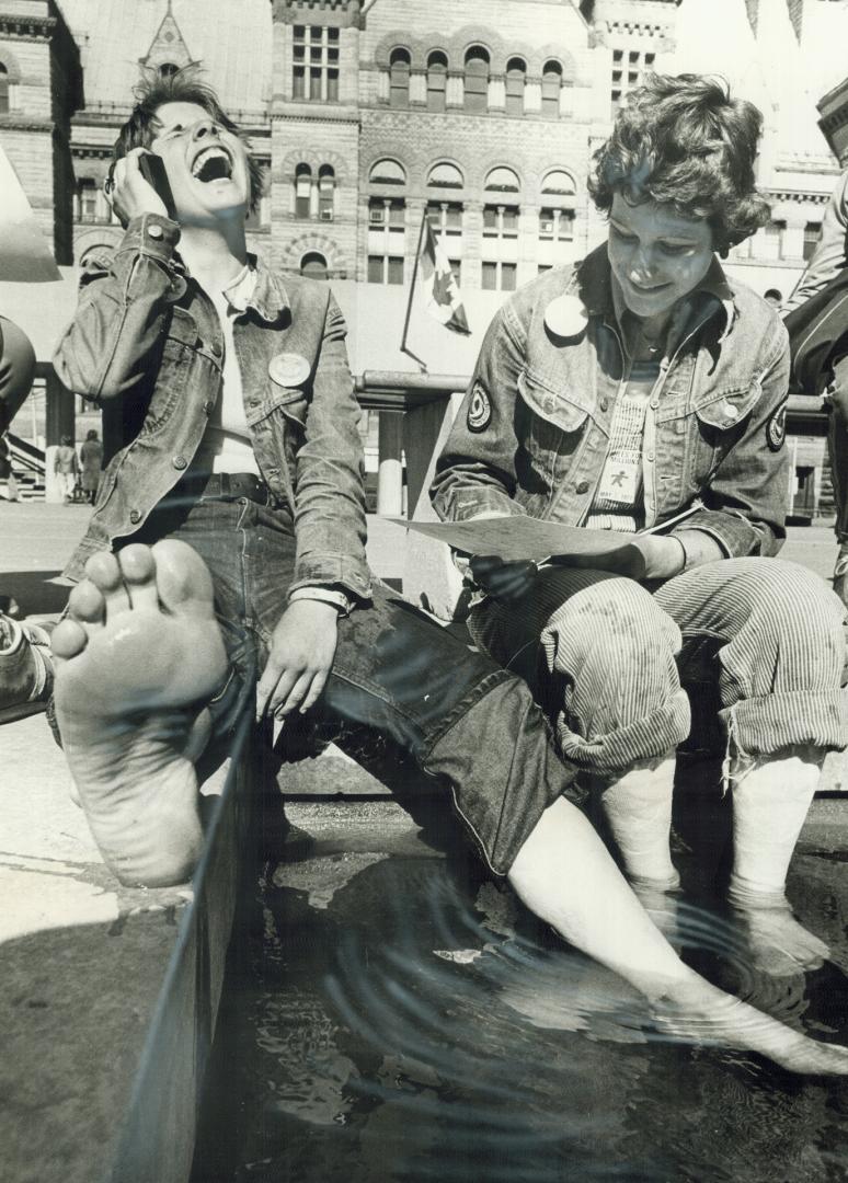 Soaking their aching feet, Bonnie Smyth, 14, left, and Wendy Jackson, 14, sit on the edge of the pool in Nathan Phillips Square after completing the 4(...)