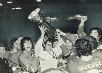 he champion Verdun Leafs skate past the wd after winning the week-long midget tournament Oshawa, captain Wayne Singleton holds the trophy high. Some m(...)