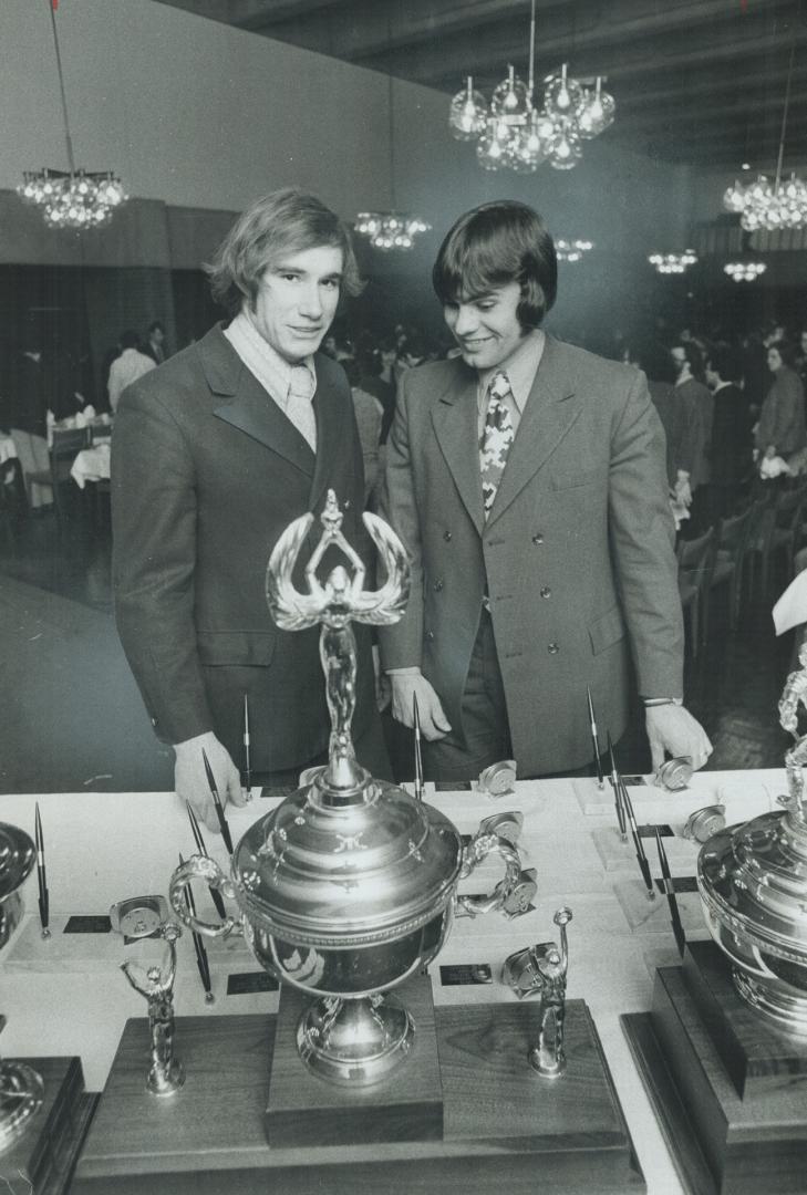 Award winners Steve Latinovich (right) of York Yeomen hockey team and gymnast Tom Kinsman (left) admire silverware at last night's York awards dinner.(...)