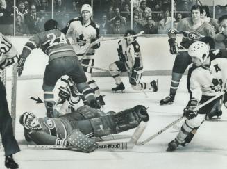 Flat on his back, Montreal Canadiens' goalie Ken Dryden is helpless to prevent puck (see arrow) fired by Leafs' Ron Ellis (right) from entering net wi(...)