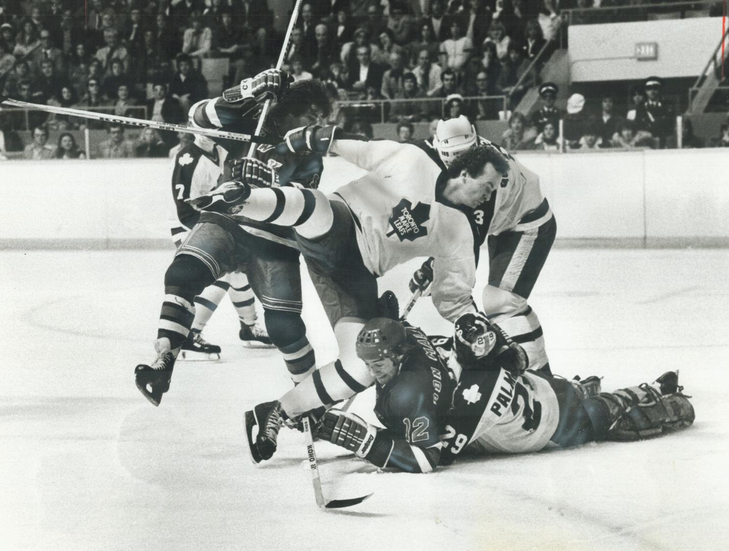 Leaf goaltender Mike Palmateer has Don Maloney in death grip as Walt McKechnie plunges in