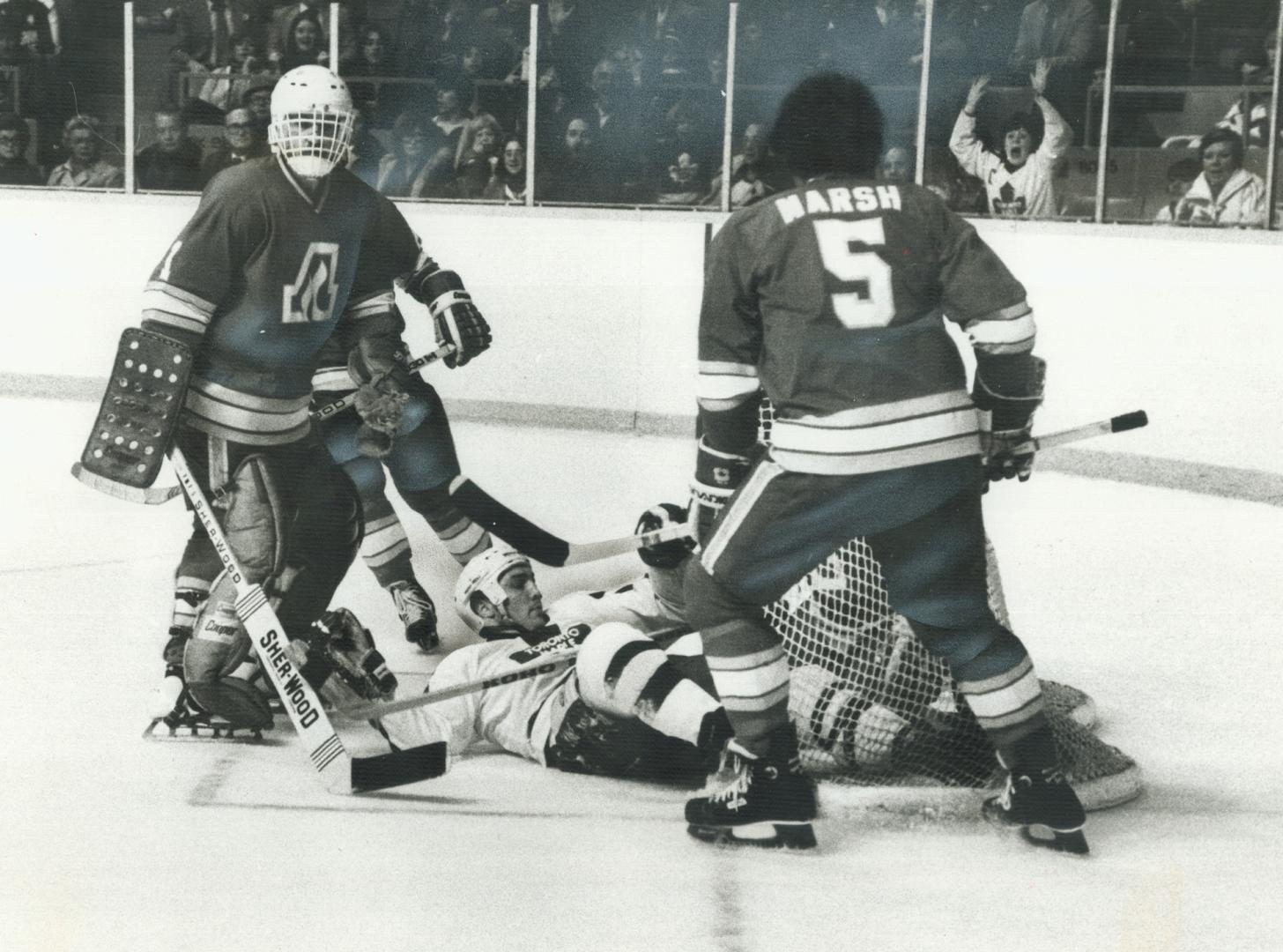 Dumped by Flames' Darcy Rota (18), Toronto's Dave (Tiger) Williams kept going and carried the puck into the Atlanta net past Rejean Lemelin for his 101st National League goal