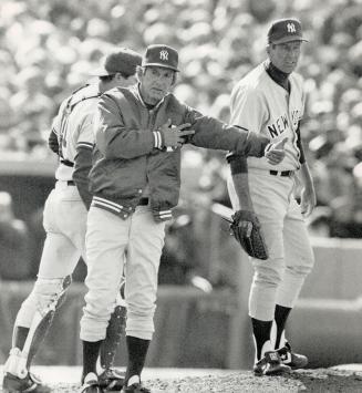 Call to arms: Lefthander Tommy John has the look of a man who knows his time is up as his manager Billy Martin makes signal for southpaw Lee Guetterman to come into game in the fourth inning