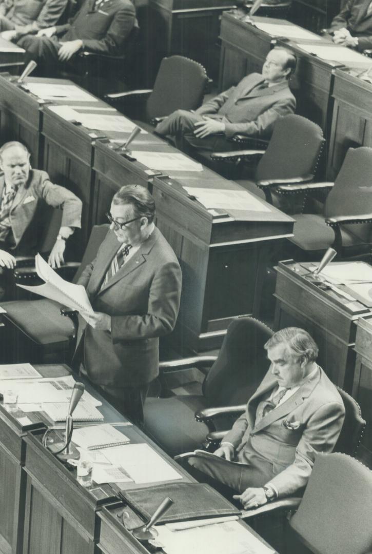 Delivering budget speech, Ontario Treasurer Charles MacNaughton stands at his desk on the floor of the Legislature today outlining policies he says wi(...)