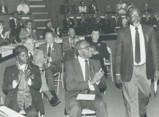 Writer and filmmaker Roger McTair is applauded by, from left, Keren Brathwaite and former lieutenant-governor Lincoln Alexander