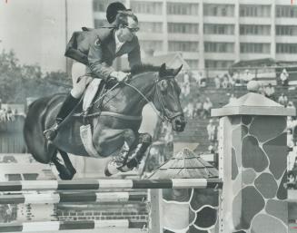 Up . . . and over. Ian Millar, on B oses his cap as he soars over a jump in the final tests for the ian Olympic Equestrian team at Varsity Stadium yes(...)