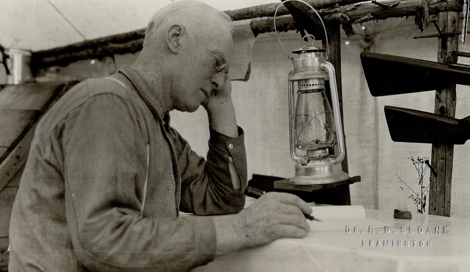 Jack Miner in his tent in land of moose writing the article deer and wolves, right where the wolves exist